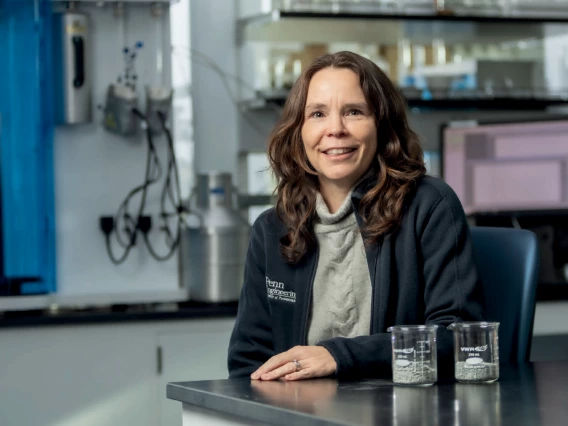 A woman with brown hair and light skin poses for a photo in a lab.