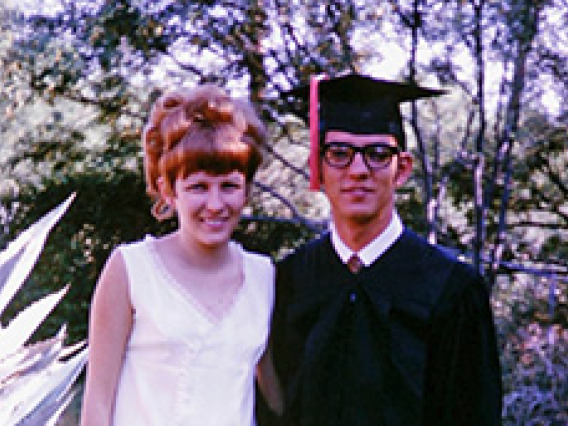 woman in white dress, man in graduation regalia