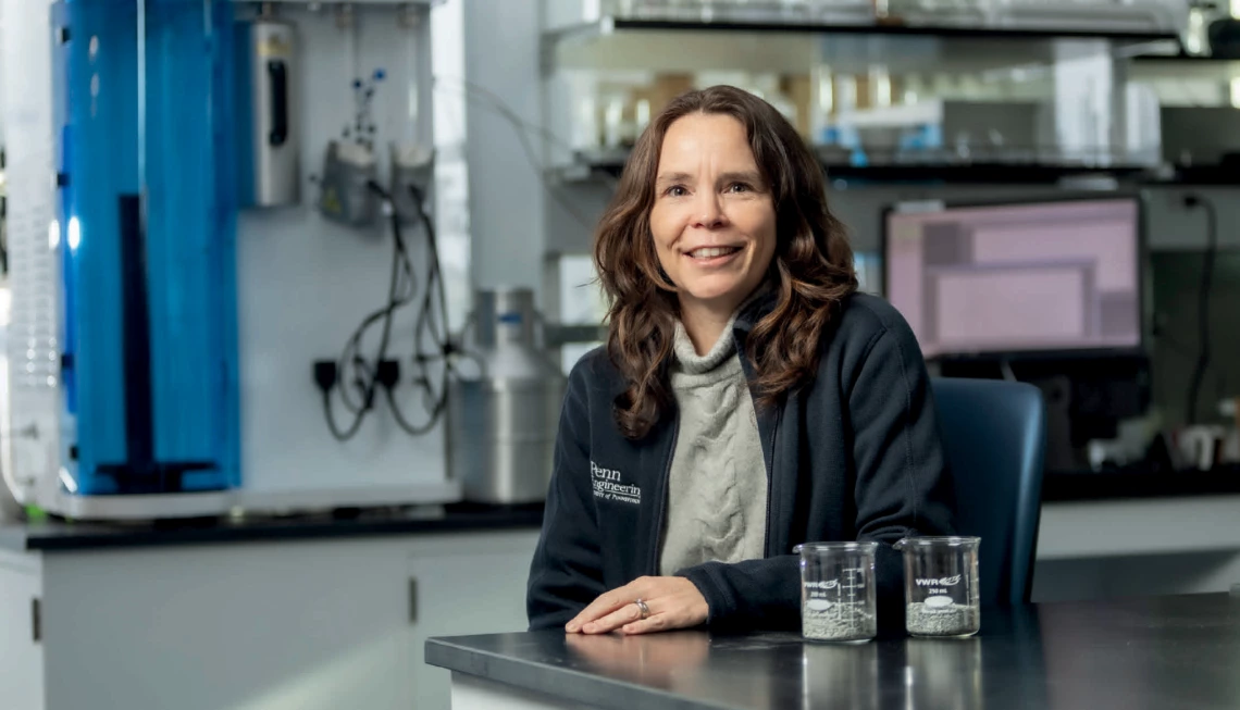 A woman with brown hair and light skin poses for a photo in a lab.