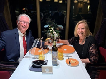 man and woman, seated at table, smiling