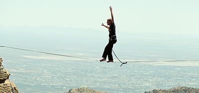 A man walks a tightrope at Windy Point in the Catalina Mountains 