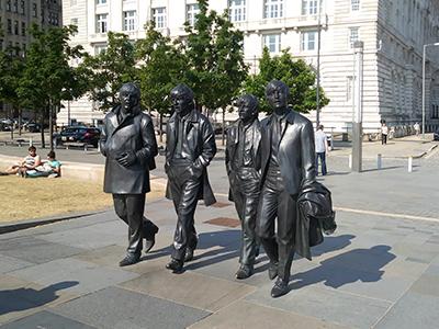 Bronze statues of the four Beatles in a park in Liverpool