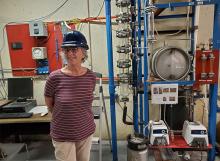 Linda Headly Repking in front of distillation column