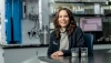 A woman with brown hair and light skin poses for a photo in a lab.