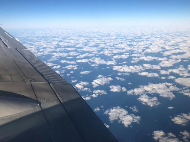A layer of clouds, as seen from above the wing of a plane.