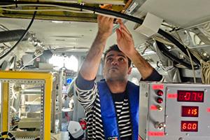 Doctoral student Hossein Dadashazar collects cloud water samples aboard the Navy Twin Otter