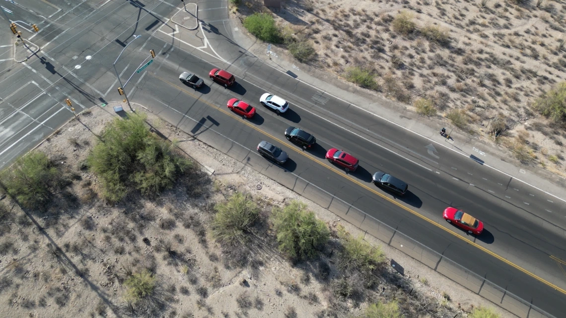 an overhead view of an intersection with cars with a person sitting near the intersection in a lawn chair