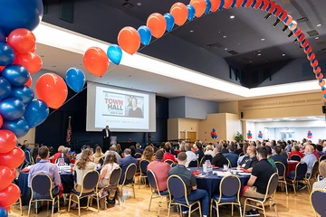homecoming attendees in grand ballroom decorated with balloons
