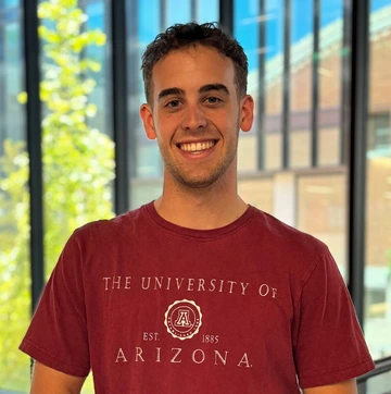 person with short, dark hair, wearing university of arizona red t-shirt